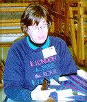 This is a picture of the late Kay Miller learning to use an Inkle Loom at a Julia Benson workshop.Kay Miller at Inkle LoomKM