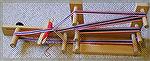 This is a photograph of an Inkle Loom, which is used to make warp-faced narrow bands of weaving.  Inkle LoomKathyMorgret