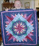 This is actually a wall-hanging my sister Suzanne made for our father for Christmas 2000.  Peggy did the quilting.  That's Dad holding it up. This one is a Mariner's Compass pattern.Suzanne's Quilt No