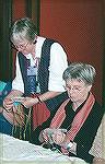 Shirley B. teaching one of her famous "Kumihimo on a card" seminars at Convergence 2002, Vancouver.  On the right, Hilburg L. concentrating on her braid.

Shirley''s Class
Rocio Vazquez