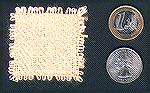 This is a sample of handspun soybean fiber, woven on a Weavette at 24 ends per inch.  The two coins (a Euro and a U.S. quarter) give you an idea of the scale of this image.Soybean yarn, wovenRuthMacGr