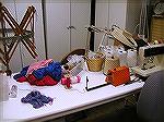 This is the worktable in my loom room (as opposed to the worktable in my dye kitchen/laundry room) on one of its better days .  Note the broccoli rubber band holding the cabinet doors shut against nos