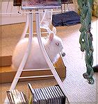 This is Zack, the incomparable angora rabbit, supervising the threading of a loom.  The loom is overhead and not in the photo; but the yarn on the right side of the picture is the chained warp.