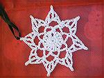 This crocheted snowflake is by Donna Barrett.  Design by LionBrand on the internet http://lionbrand.com/patterns/craft-wes-snowflake.html. From our 2004 Holiday Ornament Swap.