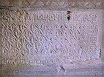 This stonework appears on the side of one of the sepulcres in the Merovingian crypt in Jouarre, France.  The motifs seem very much like woven motifs to my eyes -- border and all!