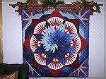 Spiral Lone Star in Red, White and Blue. This usually hangs in our entry hall. Machine quilted by a local MQ guru. 

Anne Brown