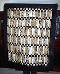 this quilt is made from fabrics with a music theme. The design is from the pattern book Allegro by Atkinson design.  The border is a black fabric with gold flecks. It has been donated to a local schoo