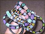 These bracelets came from Africa -- and that's just about all I know about them!  They're made of a bracelet form that's been wrapped with plastic-covered, flat yarn, and the patterning is woven in in