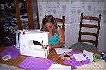 Kaylee sewing zigzag stitches down the narrow strap that we used for her bag.  You can see the bag to the right of the picture.  The purple paper around the table was leftover from driving practice.