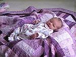 Princess Annika on her boppy throne with her quilt from Grandma.