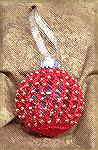 This ornament was done by Micki McCrillis. The beaded jacket is knit from a Laura Wilson design with a metallic DK yarn. The hardest part is stringing the beads on the yarn at the start.