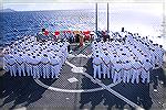 Sailors stand in formation on the helicopter flight deck of Arleigh Burke-class guided missile destroyer. 